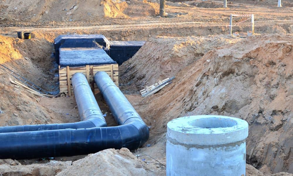 Underground stormwater detention vault installation with drainage pipes at a commercial construction site