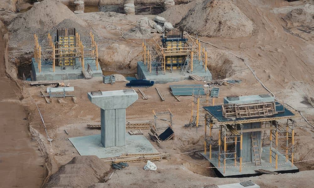 Concrete structural foundations under construction with reinforced footings and deep foundation elements transferring loads to soil