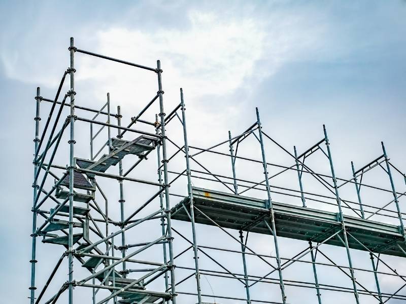 Metal scaffolding system used for construction work against a clear sky